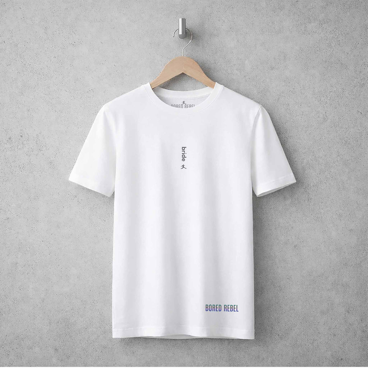 White crew neck Bored Rebel Bride T-shirt hanging on a concrete wall, showing the minimalist vertical print.