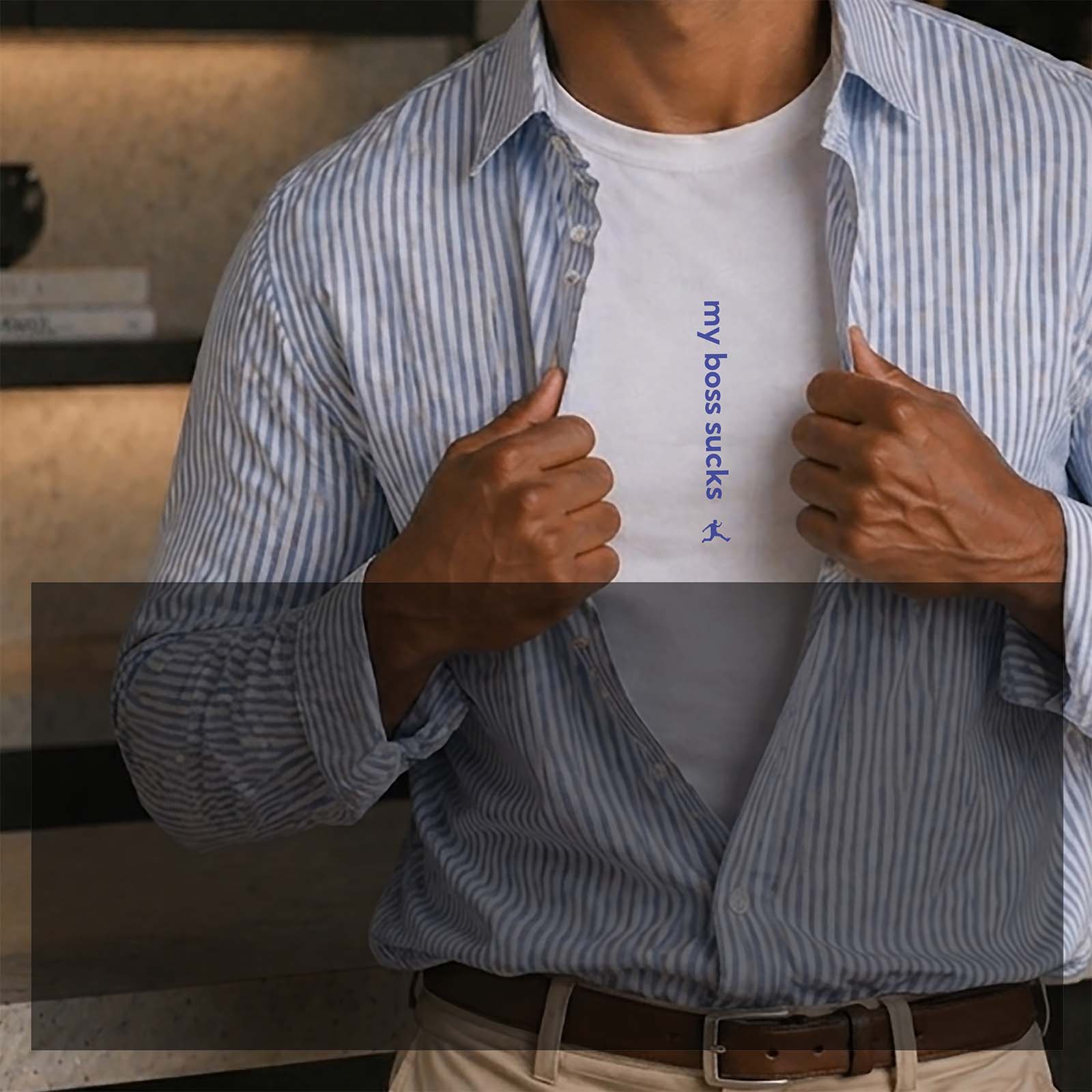 A man is opening his dress shirt superman style to reveal an undershirt with a graphic print. It reads 'my boss sucks' centered vertically on his chest.