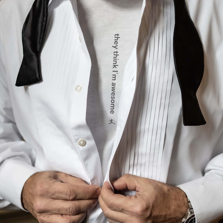 Man in a tux with bow tie open, revealing a Bored Rebel men&